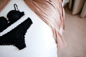 Ensemble de lingerie en dentelle noire sur fond blanc avec écharpe en soie