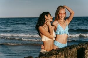 Deux femmes portant des bikinis vichy sur la plage, une tendance mode de l’été 2025.